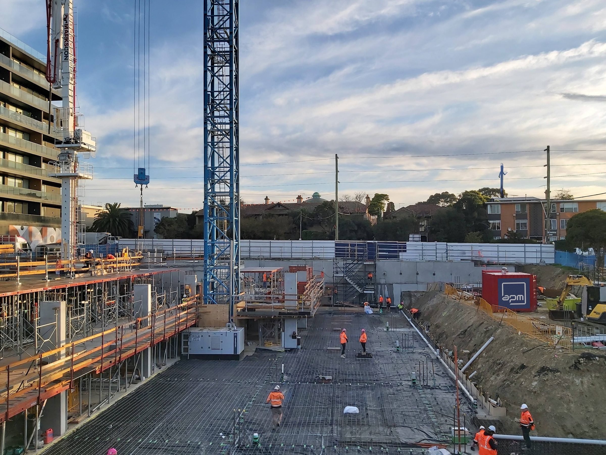 An APM Group site in progress, with slab, scaffolding and a tower crane